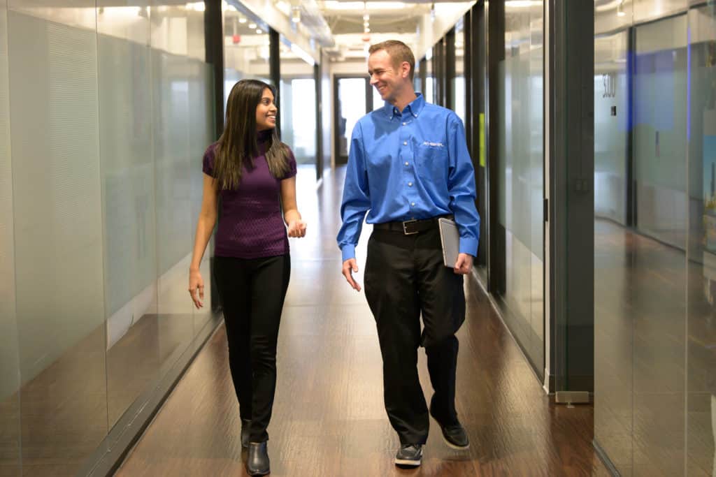 Customer and AVI-SPL support person walking in hallway