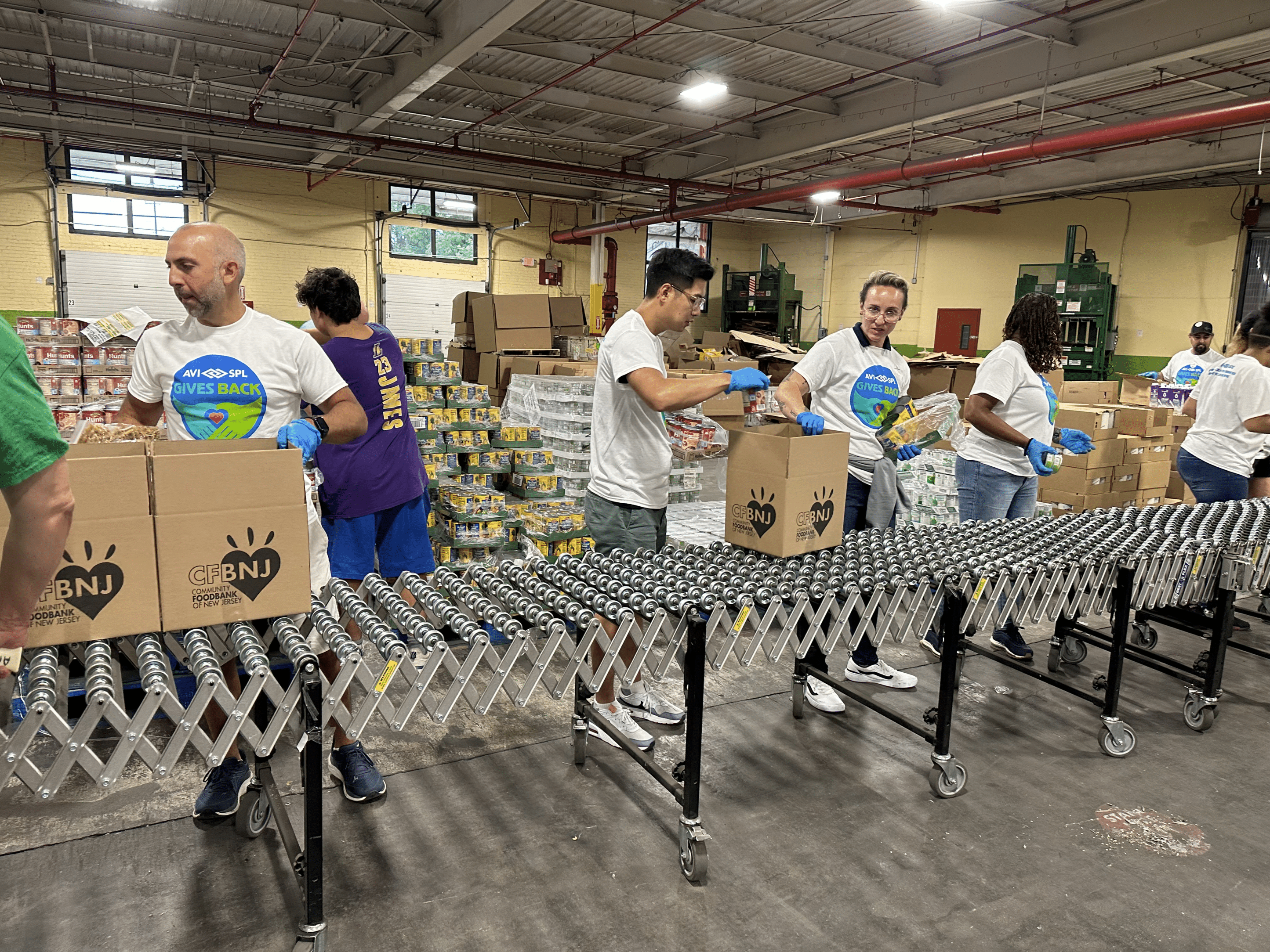 Tri-state AVI-SPL employees packing meals for the community